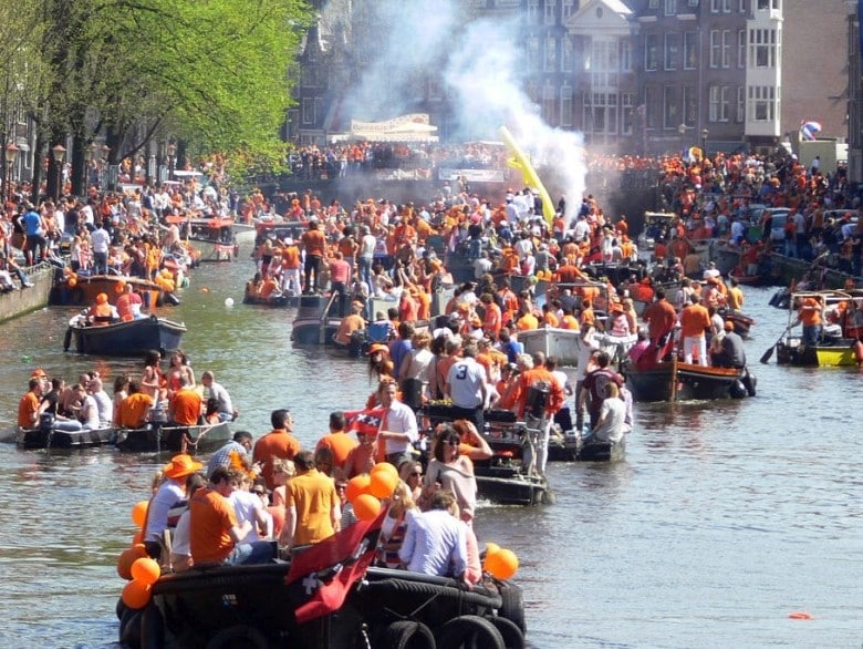 Noleggio barca Giorno del Re Amsterdam - Canali con gente in festa